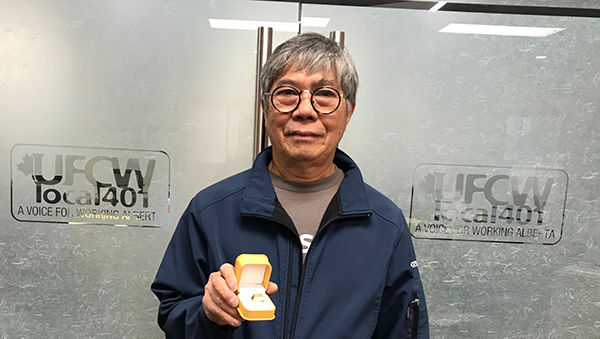 Minh Tran shows off his 401 retirement ring