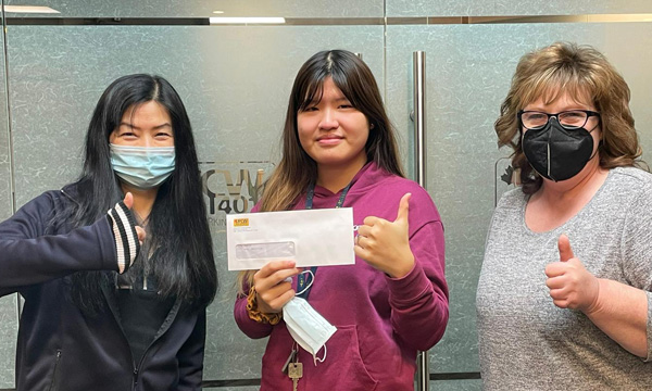 Brittany receives her scholarship cheque from Carol (L) and Darla (R)