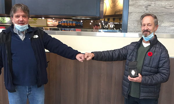 Dieter (R) receives his retirement gift from his union rep Rick