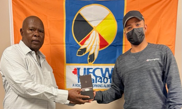 Mohamed (L) picks up his retirement gift from the union office