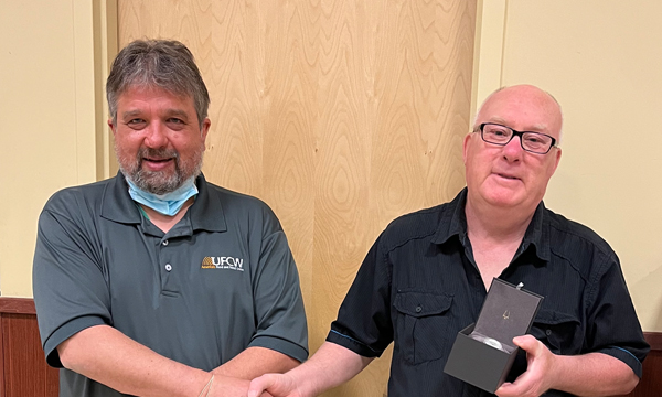 Garth is presented with his retirement watch from his union rep Rick