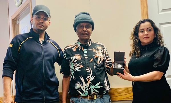 Mohamed is presented with his retirement gift by Abdalateef and Adriana from the Brooks office
